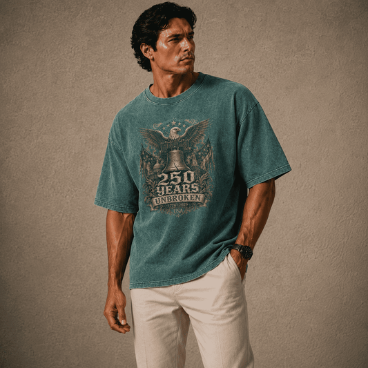 Man wearing a USA 250th Anniversary Shirt teal t-shirt with a graphic design on a beige background