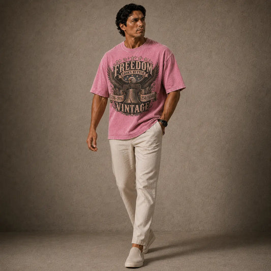 Man wearing a pink t-shirt with text and graphics, standing against a plain background