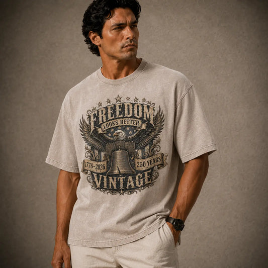 Man wearing a gray t-shirt with an eagle graphic and text on a brown background