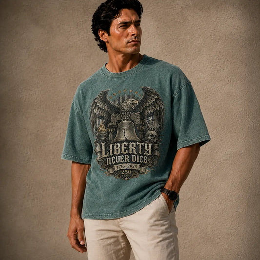 Man wearing a teal t-shirt with an eagle and bell graphic, standing against a textured beige background.