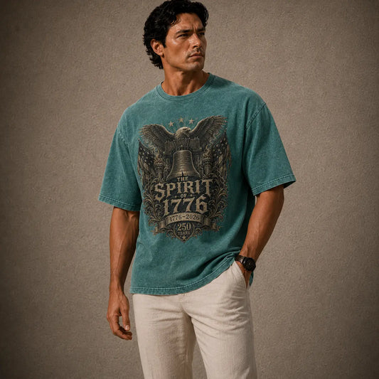 Man wearing a teal t-shirt with 'The Spirit of 1776' design against a brown background