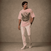 Man wearing a USA 250th Anniversary 1776 Skull Eagle pink t-shirt with a graphic design against a plain background