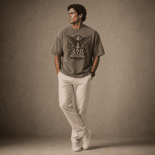 Man wearing a USA 250th Anniversary Shirt graphic t-shirt and light pants against a plain background