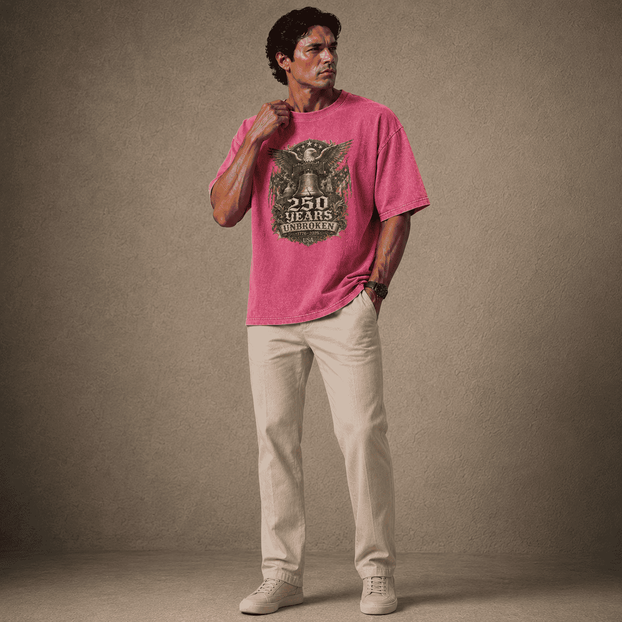 Man wearing a USA 250th Anniversary Shirt pink t-shirt with a graphic design on a plain background