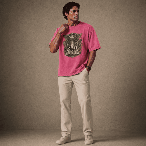 Man wearing a USA 250th Anniversary Shirt pink t-shirt with a graphic design on a plain background