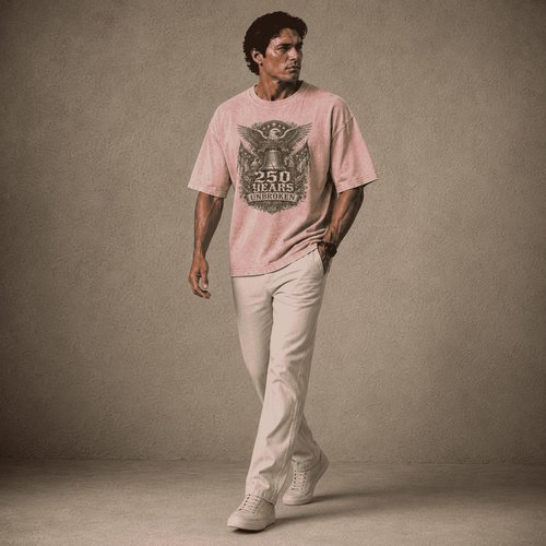 Man wearing a USA 250th Anniversary Shirt pink t-shirt with a graphic design and beige pants against a brown background
