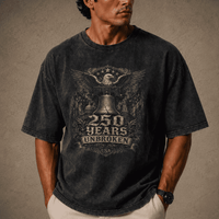 Man wearing USA 250th Anniversary Shirt a black t-shirt with a graphic design on a brown background