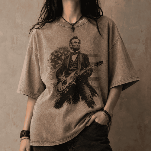 Person wearing a t-shirt with a graphic of Abraham Lincoln playing a guitar against a concrete wall.