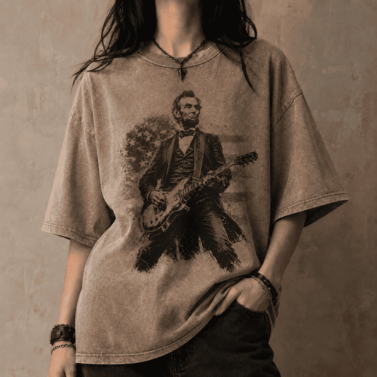 Person wearing a t-shirt with a graphic of Abraham Lincoln playing a guitar against a concrete wall.