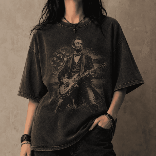 Person wearing a black t-shirt with a graphic of a historical figure playing a guitar against a plain background