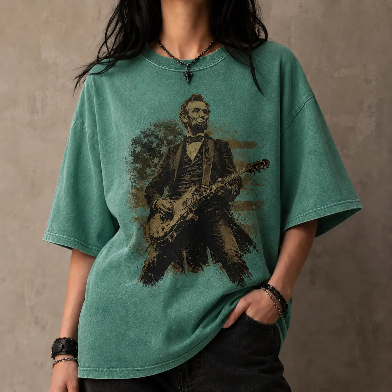 Person wearing a green t-shirt with a graphic of Abraham Lincoln playing a guitar against a plain background