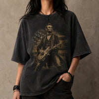 Person wearing a black t-shirt with a graphic of a historical figure playing a guitar against a plain background