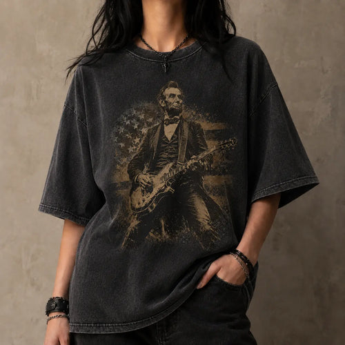 Person wearing a black t-shirt with a graphic of a historical figure playing a guitar against a plain background