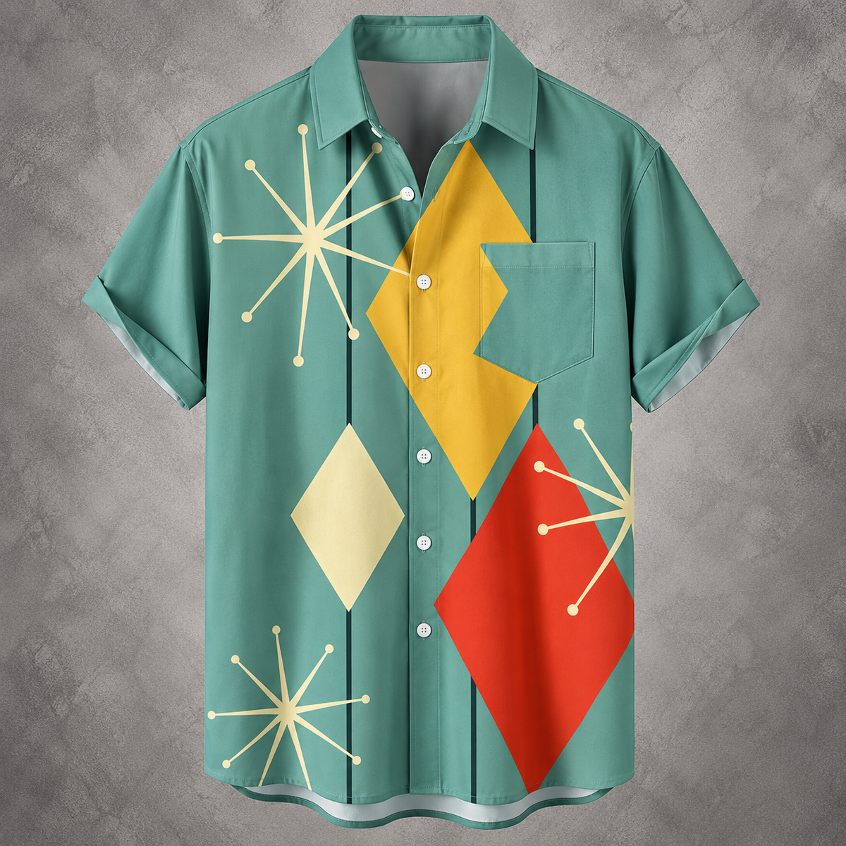 A short-sleeve button-up shirt with a retro mid-century modern pattern, featuring a teal green base with yellow, red, and cream geometric shapes, displayed on a textured gray background.