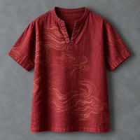 A short-sleeve red linen tunic shirt with a wavy cloud-like pattern in a lighter rust tone, featuring a split neckline, laid flat on a textured gray background.
