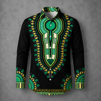 A long-sleeve button-up shirt with a black base and an intricate green, yellow, and white dashiki-style print, displayed on a gray textured background.