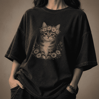 Person wearing a black t-shirt with a cat and floral design on a dark background