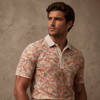 Man wearing a floral patterned shirt against a textured wall