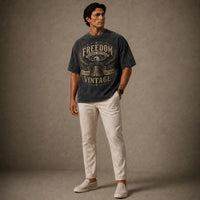 Man wearing a graphic t-shirt and light pants against a plain background