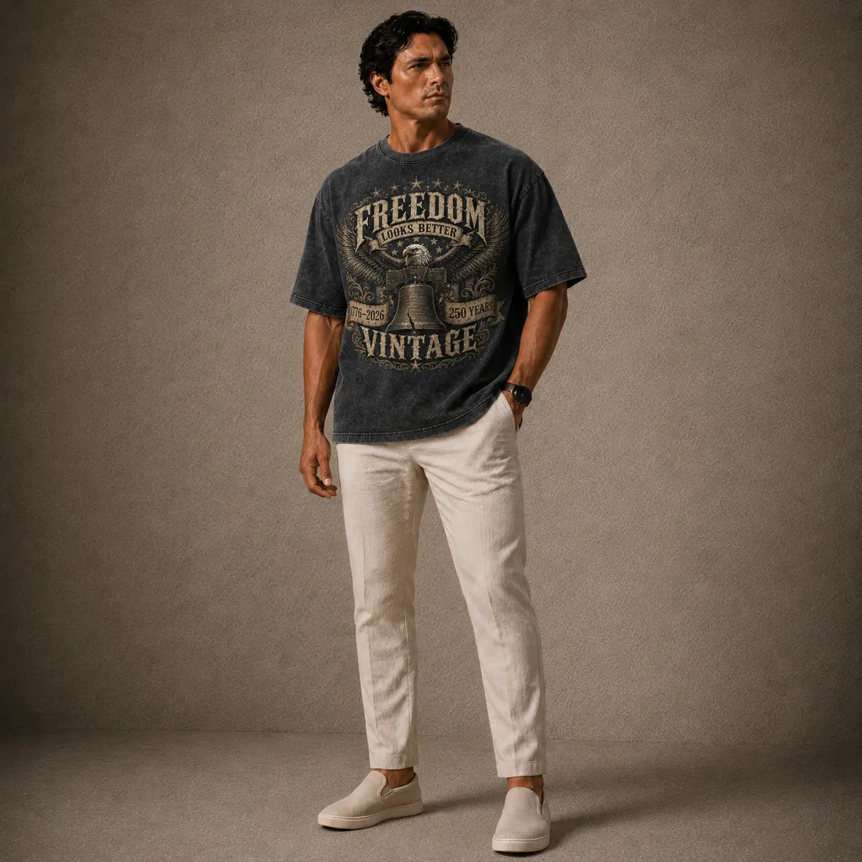 Man wearing a graphic t-shirt and light pants against a plain background
