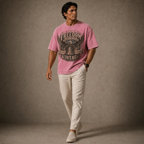Man wearing a pink t-shirt with text and graphics, standing against a plain background