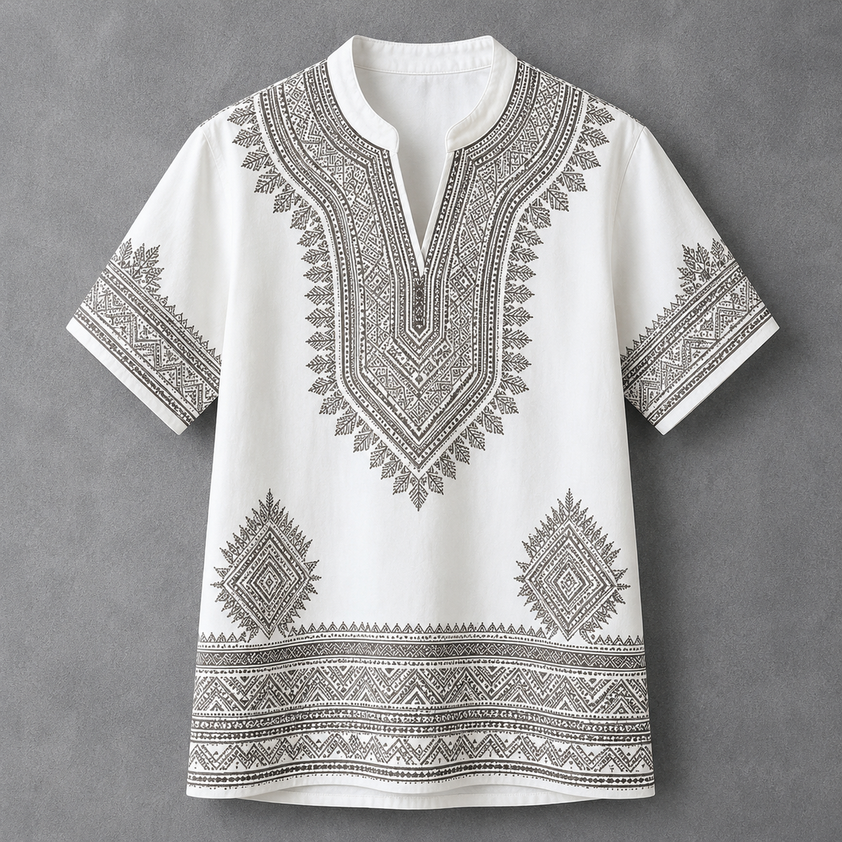 A white short-sleeve tunic top with detailed black geometric and tribal-style embroidery, featuring a split neckline and decorative patterns on the chest, sleeves, and hem, displayed against a textured gray background.