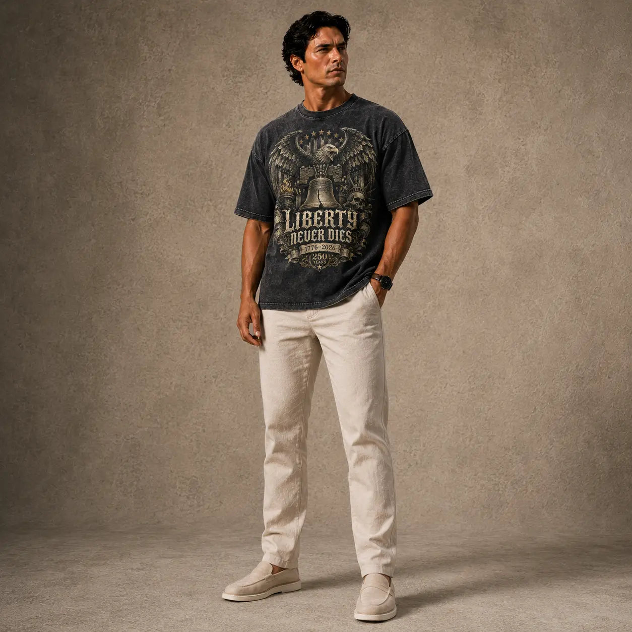 Man wearing a graphic t-shirt and light-colored pants against a textured brown background