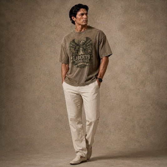 Man wearing a graphic t-shirt and light-colored pants against a textured brown background
