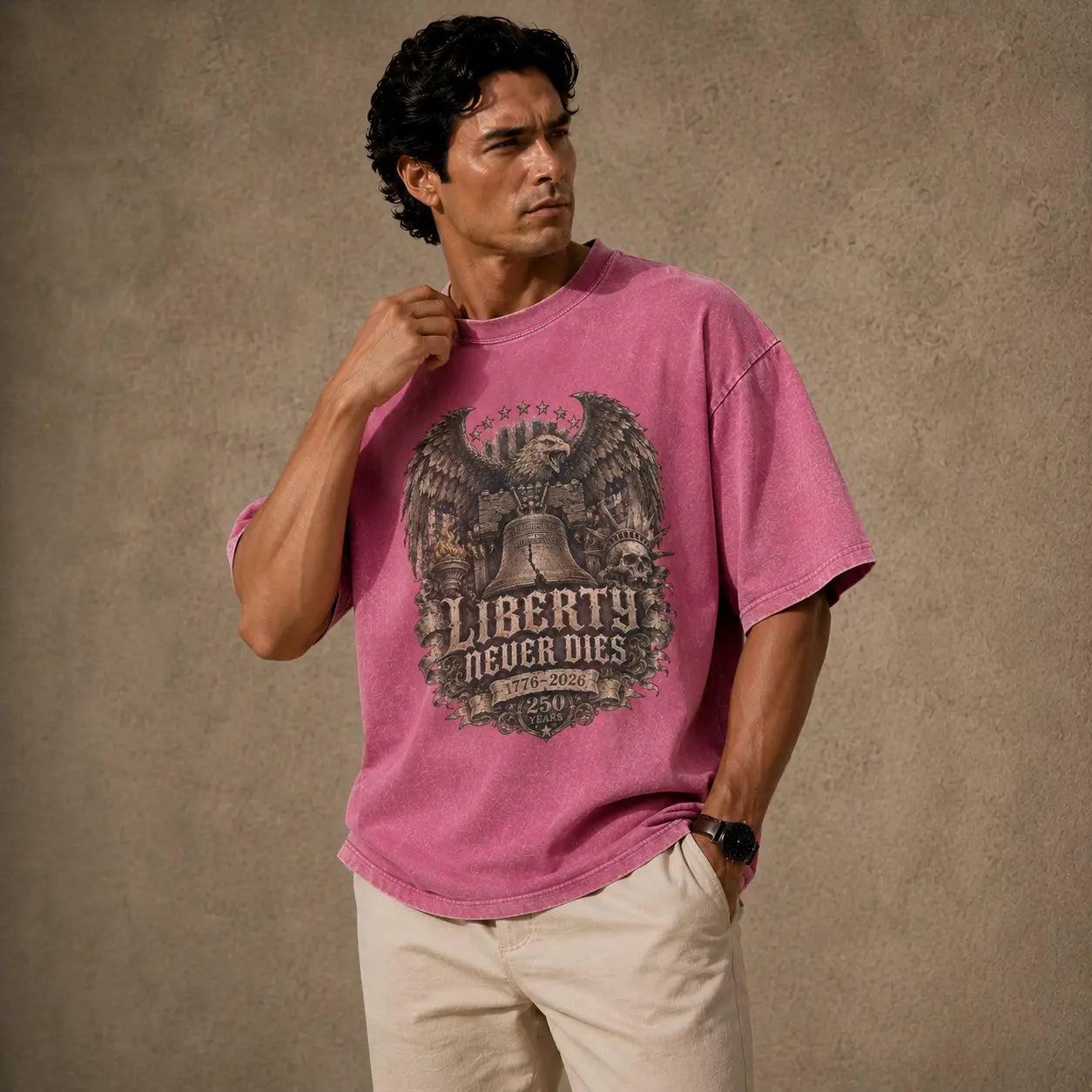 Man wearing a pink t-shirt with an eagle and liberty bell graphic against a brown background