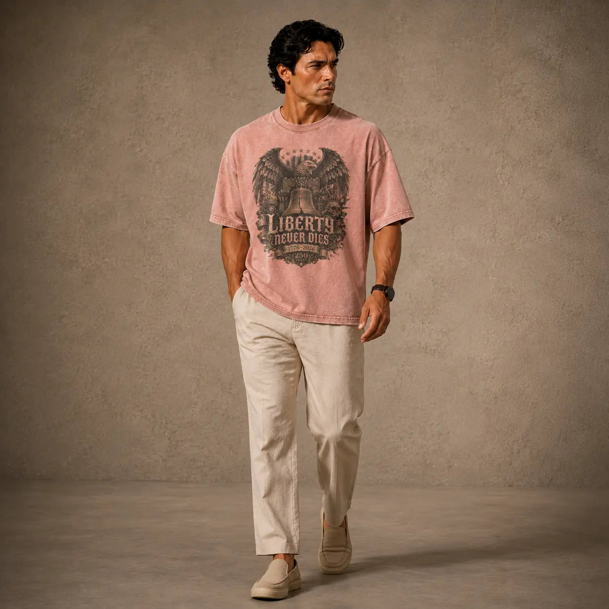 Man wearing a pink t-shirt with a graphic design and text, standing against a plain background