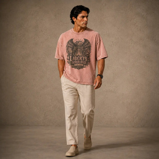 Man wearing a pink t-shirt with a graphic design and text, standing against a plain background