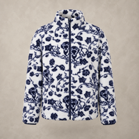 A white fleece zip-up jacket featuring a navy blue floral and branch pattern, displayed against a neutral textured beige background.