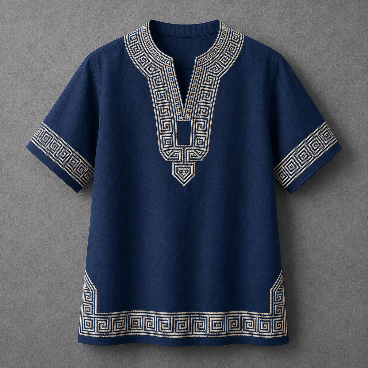 A navy blue short-sleeve tunic top with white geometric embroidery on the neckline, sleeve cuffs, and hem, displayed flat against a textured gray background.