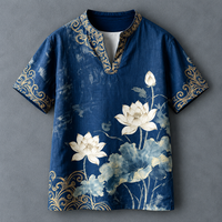 A men's short-sleeve tunic-style shirt in dark blue with a watercolor lotus print in white and light blue, featuring gold ornamental scrollwork trim along the collar, sleeve cuffs, and lower hem, displayed flat against a textured gray background.