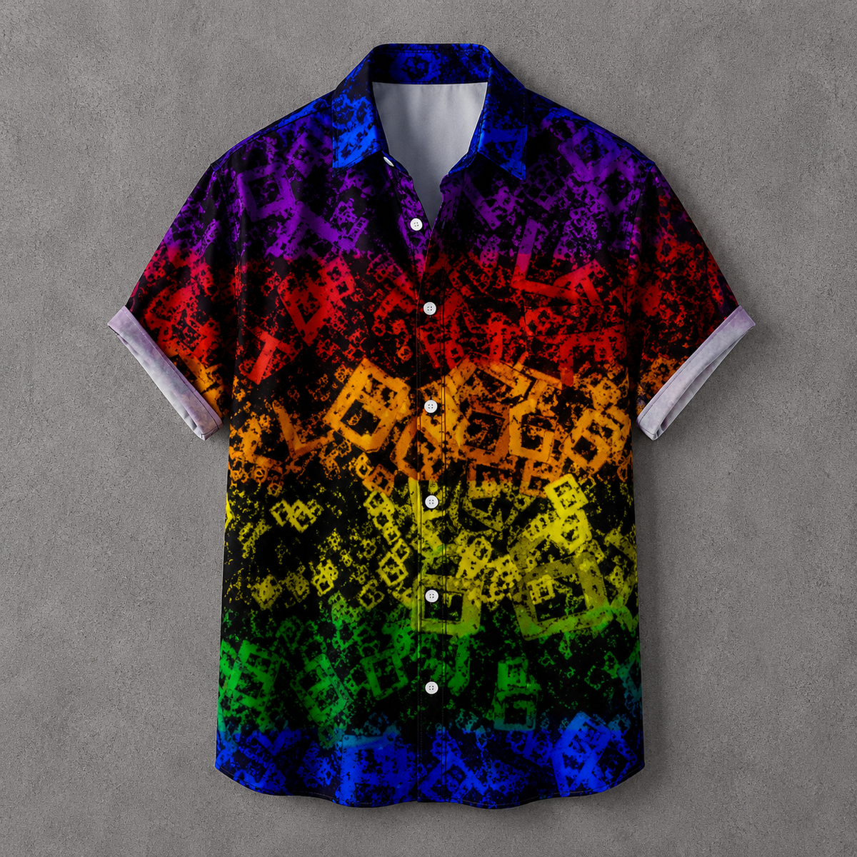 A short-sleeve button-up camp shirt with a vibrant rainbow gradient transitioning from purple and blue at the top to red, orange, yellow, and green at the bottom. The shirt features a black background patterned with repeating white and black geometric shapes, and is displayed against a textured gray background.