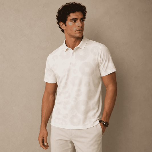 Man wearing a white polo shirt and beige pants against a beige background
