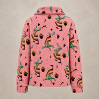 A pink sherpa fleece jacket with an all-over whimsical print of dancing figures, acorns, and small black shapes, shown against a neutral textured beige background.