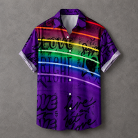 A short-sleeve button-up camp shirt with a vibrant purple base, rainbow stripe accents, and black graffiti-style text, displayed flat against a textured gray background.