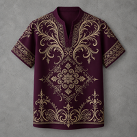 A short-sleeve polo shirt in deep burgundy with an intricate gold baroque-style damask pattern, laid flat against a textured gray background.