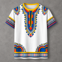 A white short-sleeve t-shirt with a vibrant African dashiki print featuring blue, yellow, and red patterns on the chest, collar, sleeves, and hem, displayed flat against a gray textured background.