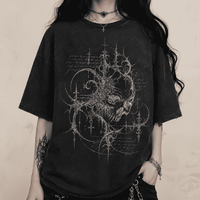 Person wearing a black t-shirt with intricate design on a dark background
