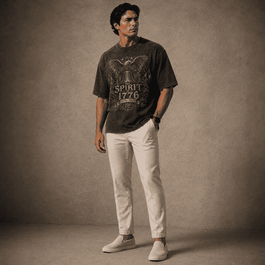 Man wearing a graphic t-shirt and light-colored pants against a textured brown background