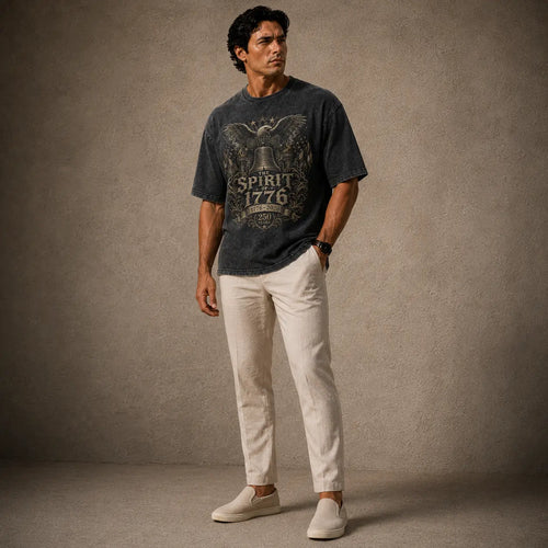 Man wearing a graphic t-shirt and light-colored pants against a textured brown background
