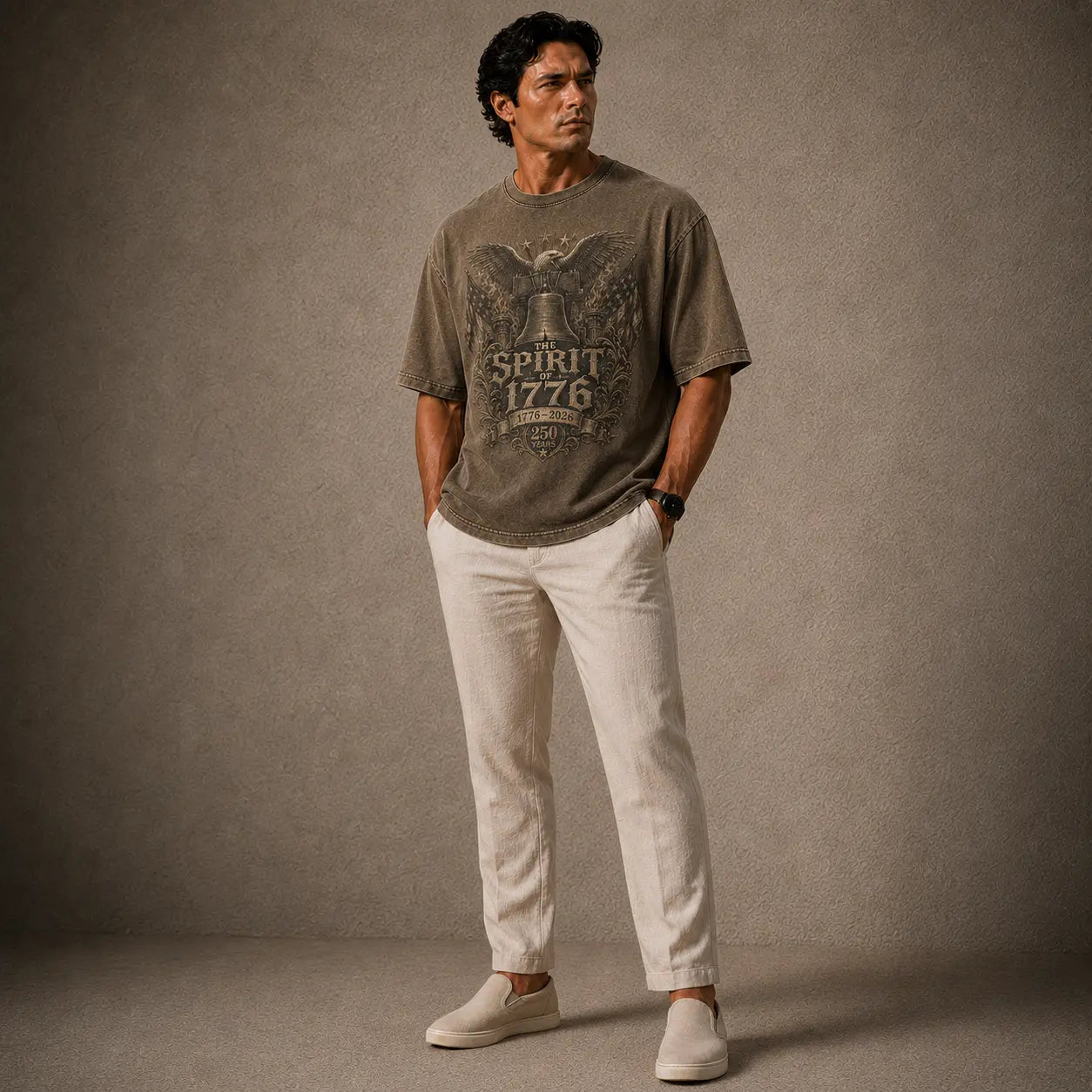 Man wearing a graphic t-shirt and white pants against a gray background