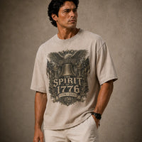 Man wearing a t-shirt with 'The Spirit of 1776' design on a textured brown background
