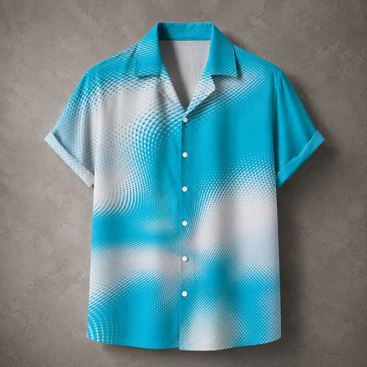 A short-sleeve button-up camp shirt with a vibrant turquoise and white halftone dot gradient pattern, displayed flat against a textured gray background.