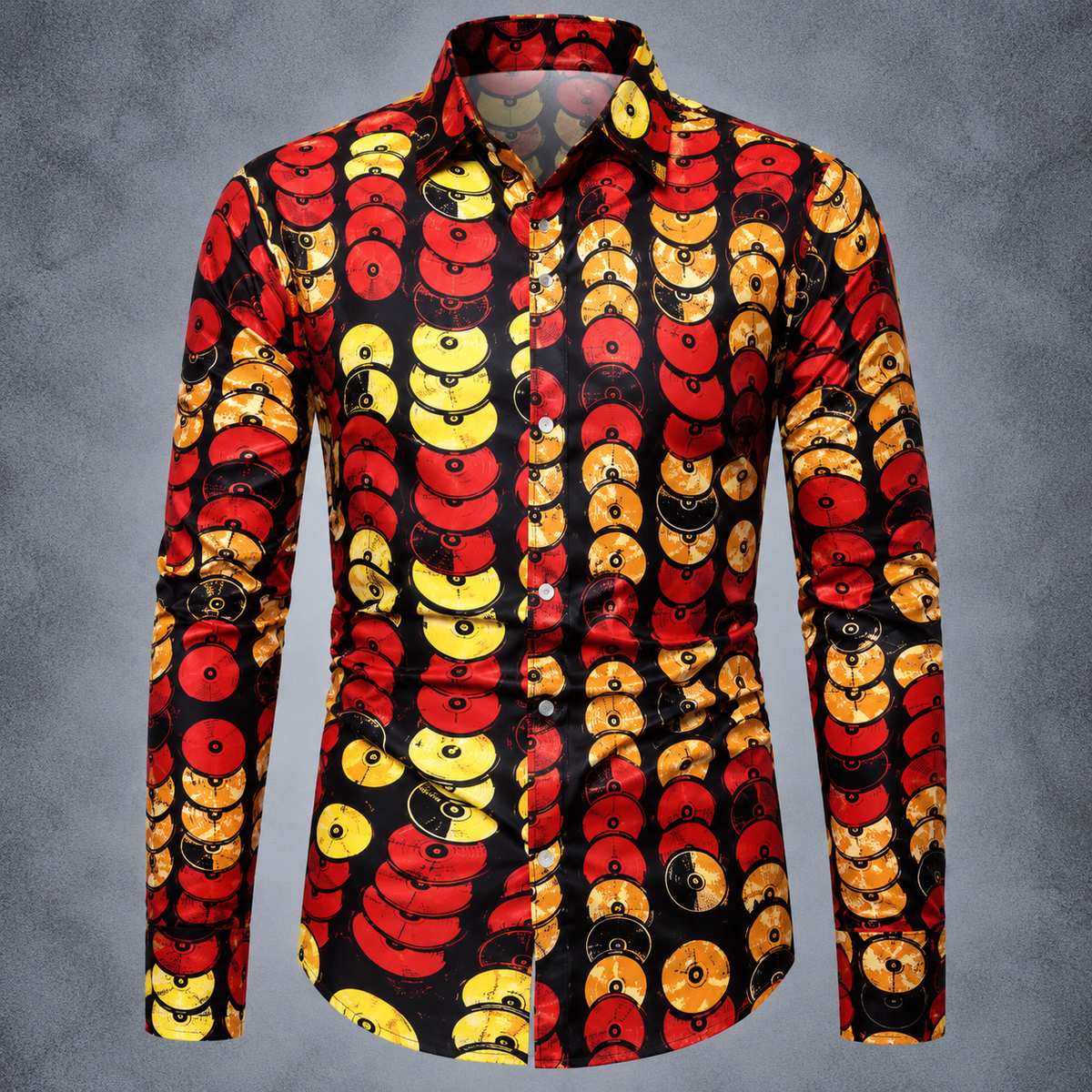 A men's long-sleeve button-up shirt with a bold African wax print pattern featuring red, yellow, and orange circular motifs on a black background, displayed on a gray textured backdrop.