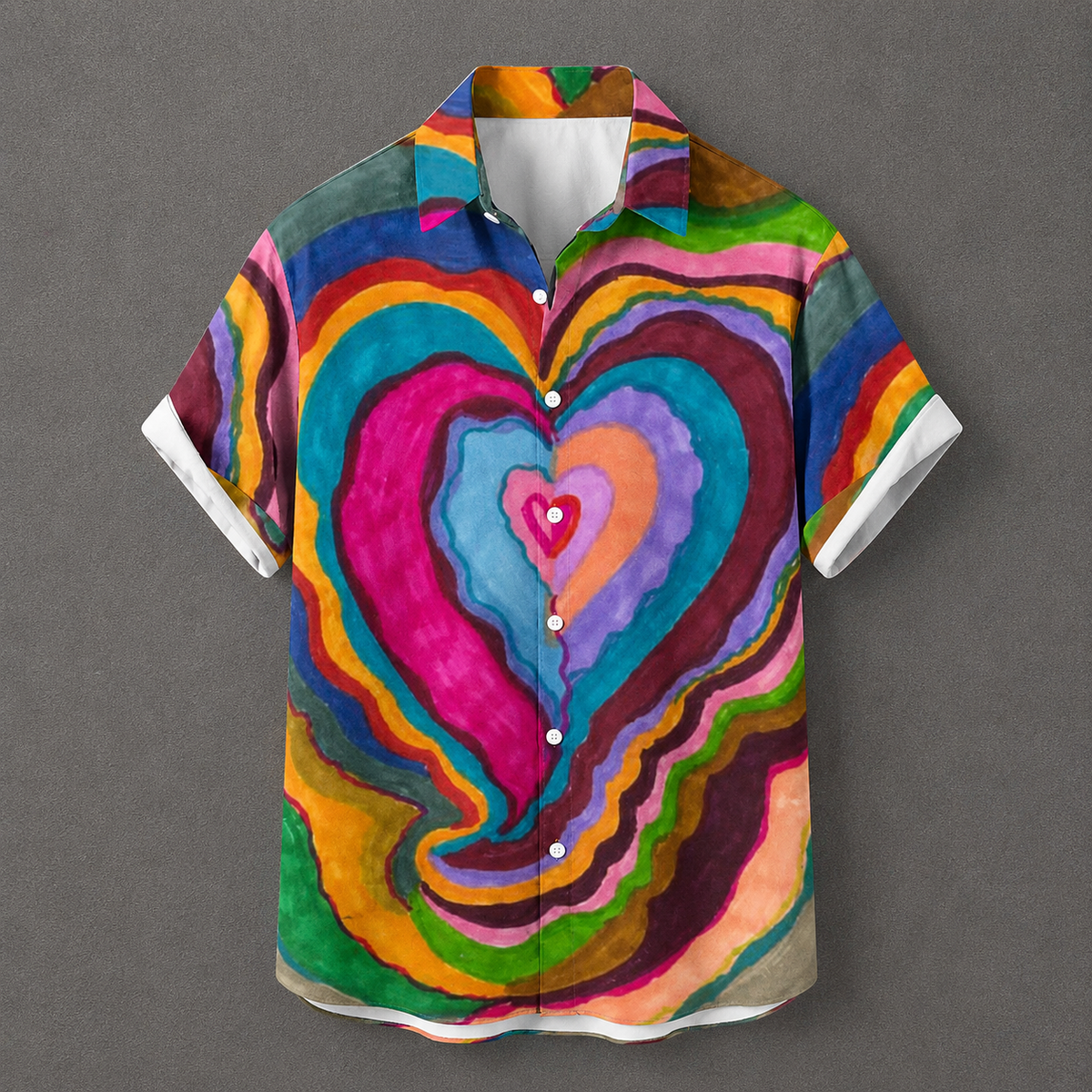 A short-sleeve button-up camp shirt with a vibrant, multicolored psychedelic heart pattern, displayed flat against a neutral gray background.