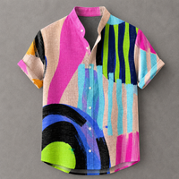 A short-sleeve button-up shirt with a bold abstract print featuring bright pink, turquoise, lime green, navy, black, and beige brushstroke patterns, displayed flat against a neutral gray background.