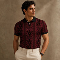 Man wearing a patterned polo shirt against a beige wall